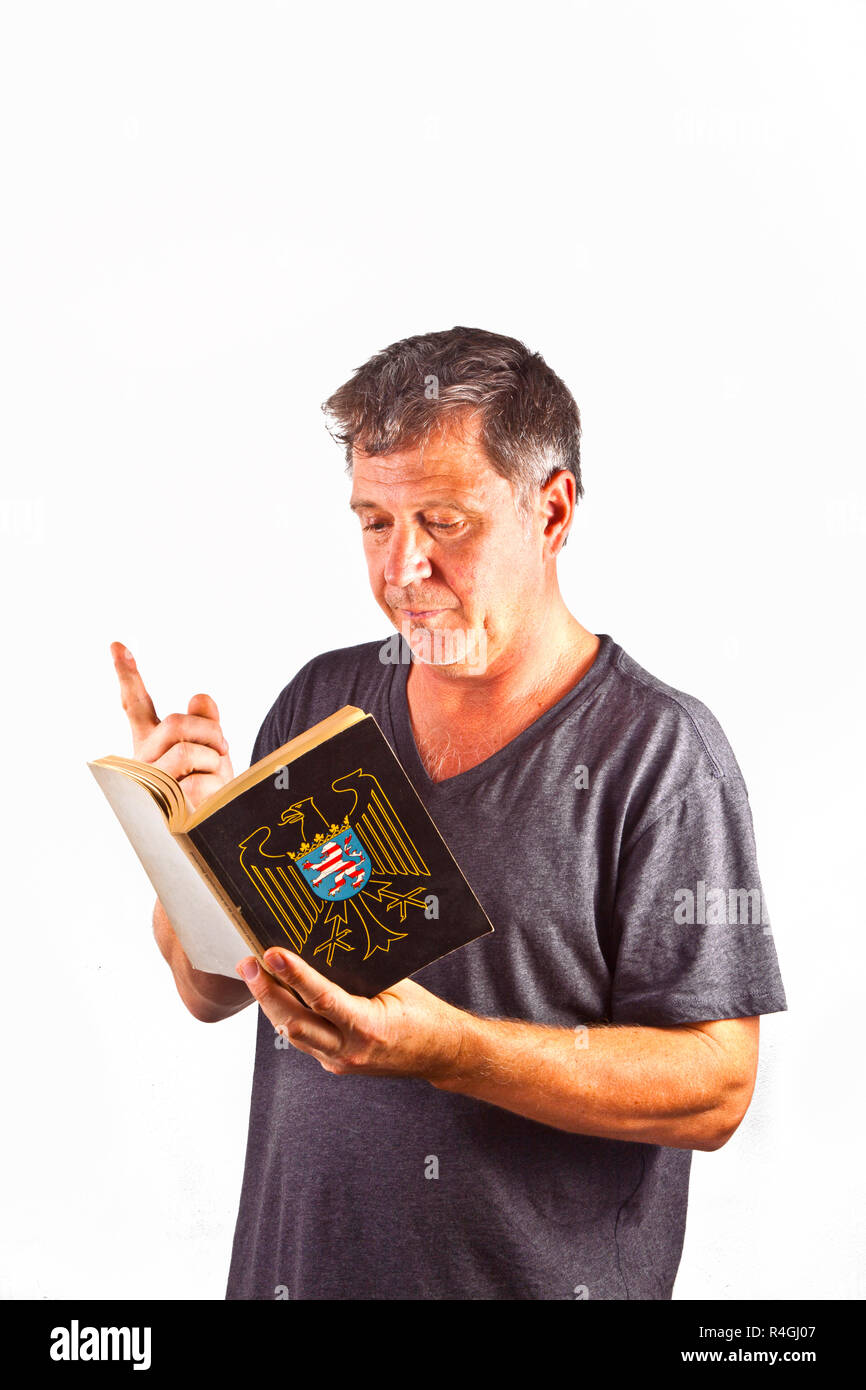 Uomo con occhiali lettura in un libro Foto Stock
