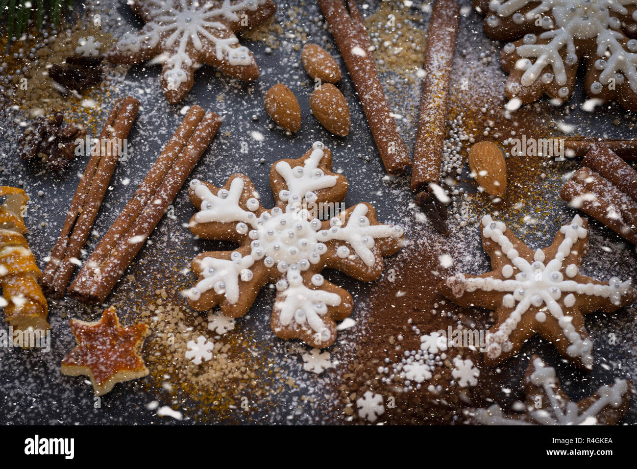 Natale o Capodanno sfondo di Gingerbread cookie, spezie, frutta con zucchero e fiocchi di neve. Vista dall'alto. Foto Stock