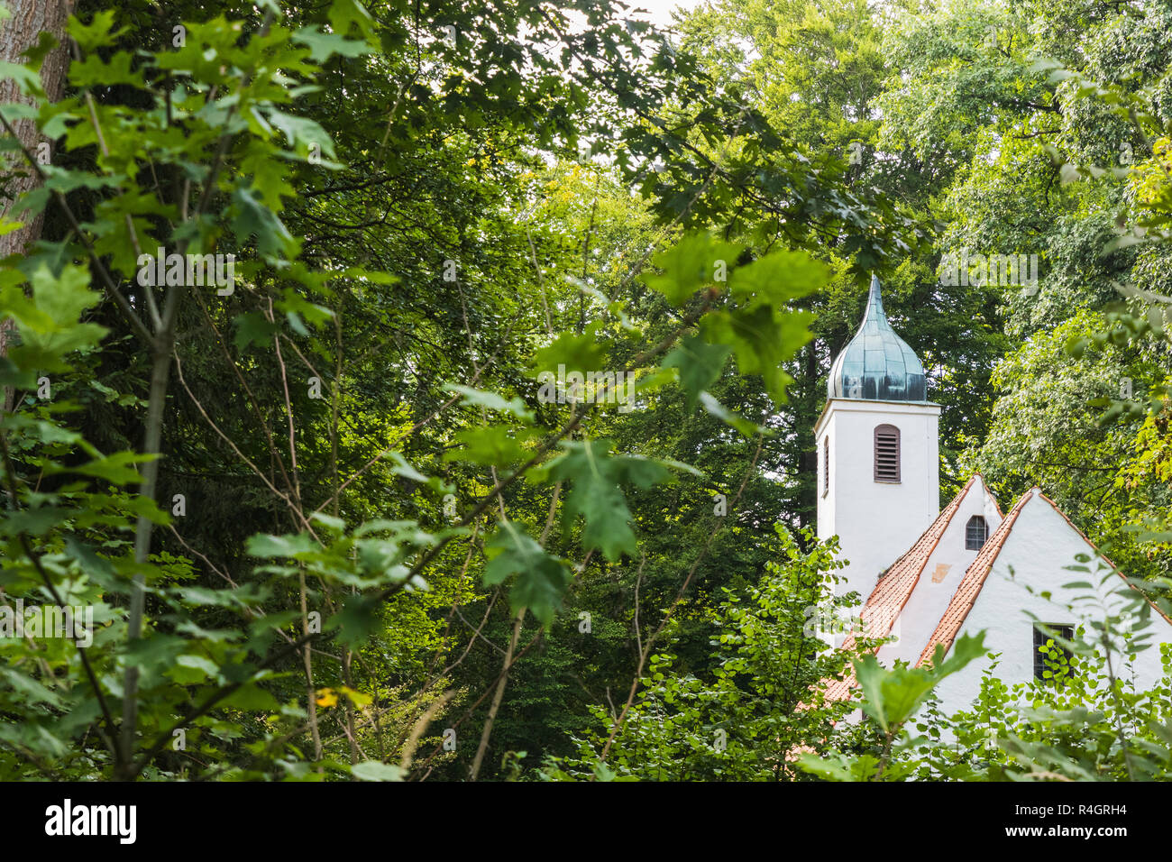 Una chiesa nascosto tra gli alberi di una foresta Foto Stock