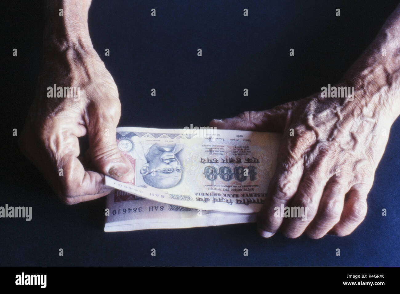 Uomo vecchio conteggio carta moneta 1000 rupie, Mumbai, India, Asia Foto Stock