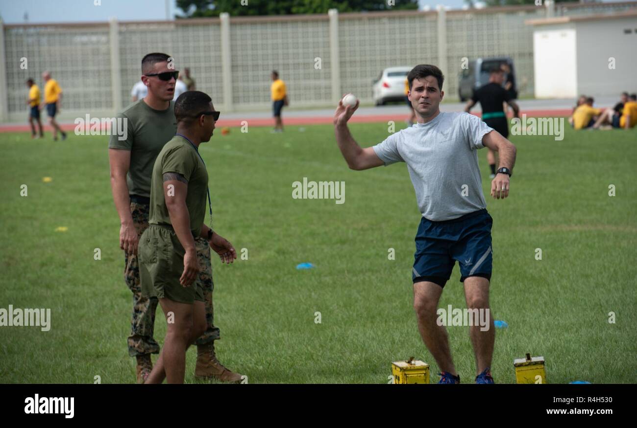 Un U.S. Air Force Airman getta un baseball durante il giunto di Okinawa sfida Fitness sett. 26, 2018 a Kadena Air Base, Giappone. Durante la sfida, baseballs sono state utilizzate per simulare le granate. Team sono stati detratti i punti sulla base della precisione del loro getta. Foto Stock
