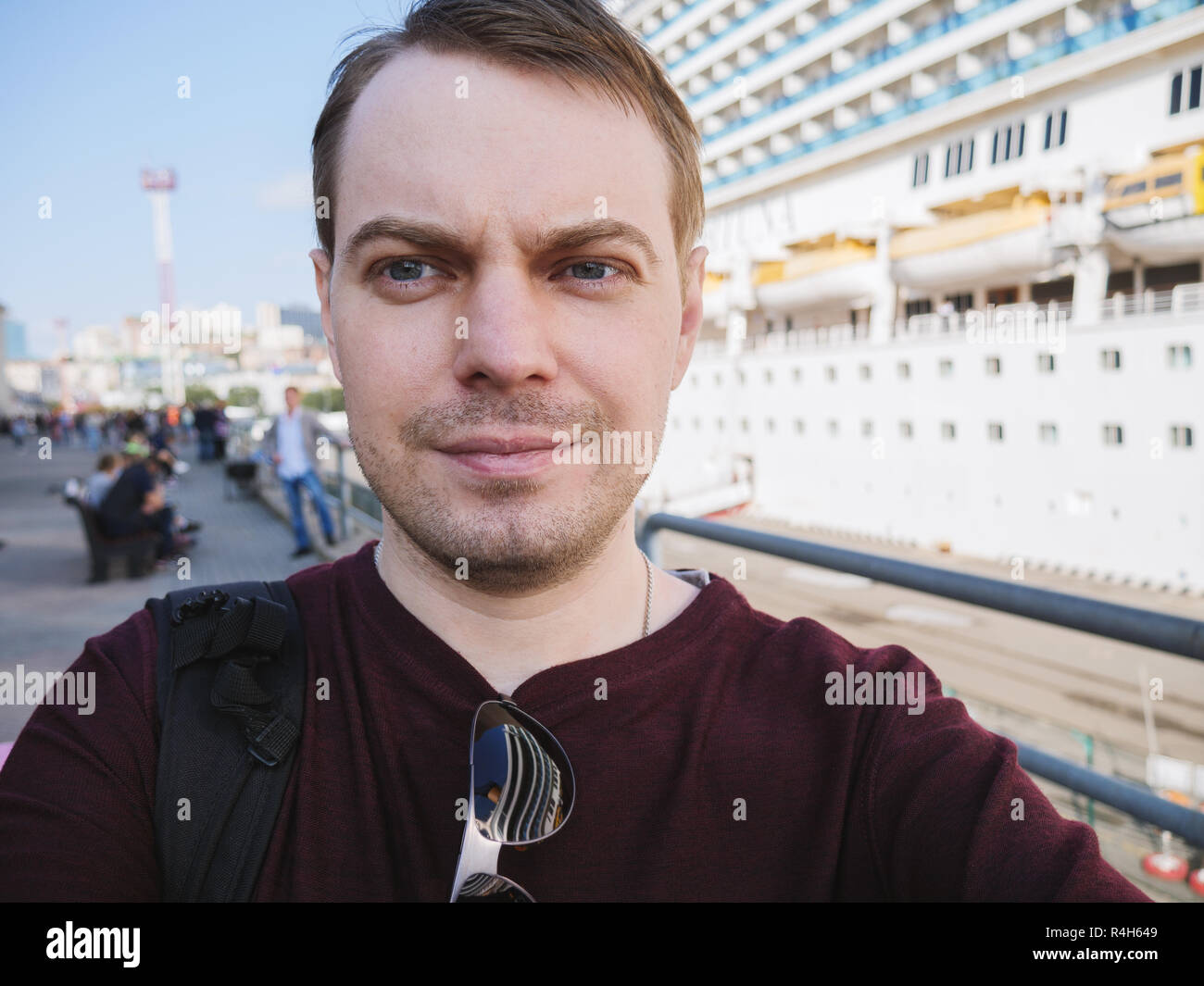 Giovane fa selfie vicino a una nave da crociera. Foto Stock