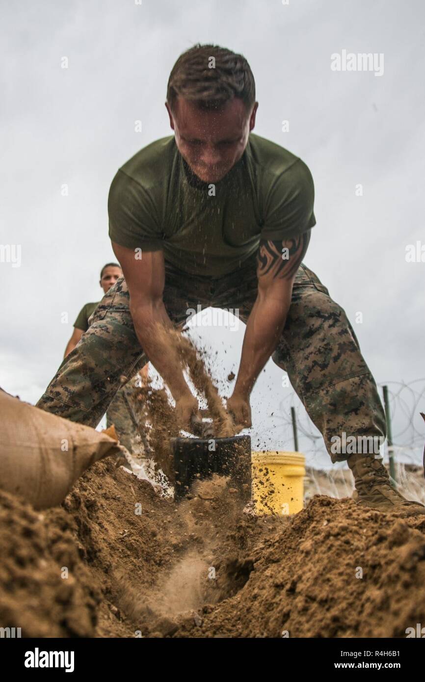 Stati Uniti Marine Corps Sgt. Giacobbe Wright, autoveicolo operatore assegnato a scopo speciale Air-Ground Marine Task Force Response-Central crisi il comando 19.1, utilizza un attrezzo di consolidamento (E-tool) per scavare una trincea per l'interramento di filo durante la Taloni esercizio 1-19 al Marine Corps Air Station Yuma, Arizona, Sett. 30, 2018. TALONEX è un pre-distribuzione evento di formazione che integra elementi dell'SPMAGTF e prove delle loro capacità quando si trovano di fronte con simulazione di scenari. Marines hanno preso precauzioni come scavando trincee e riempimento dei sacchi di sabbia nella preparazione delle intemperie che è stata sostenuta durante il exerci Foto Stock
