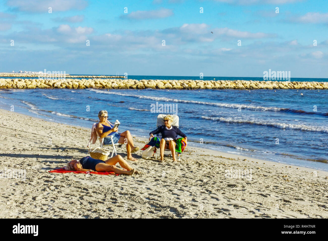 Spagna Santa Pola Beach donne anziane anziane Costa Blanca pensionati sulla spiaggia anziani adulti tre donne anziane generazione pensionati vecchiaia scena di novembre Foto Stock