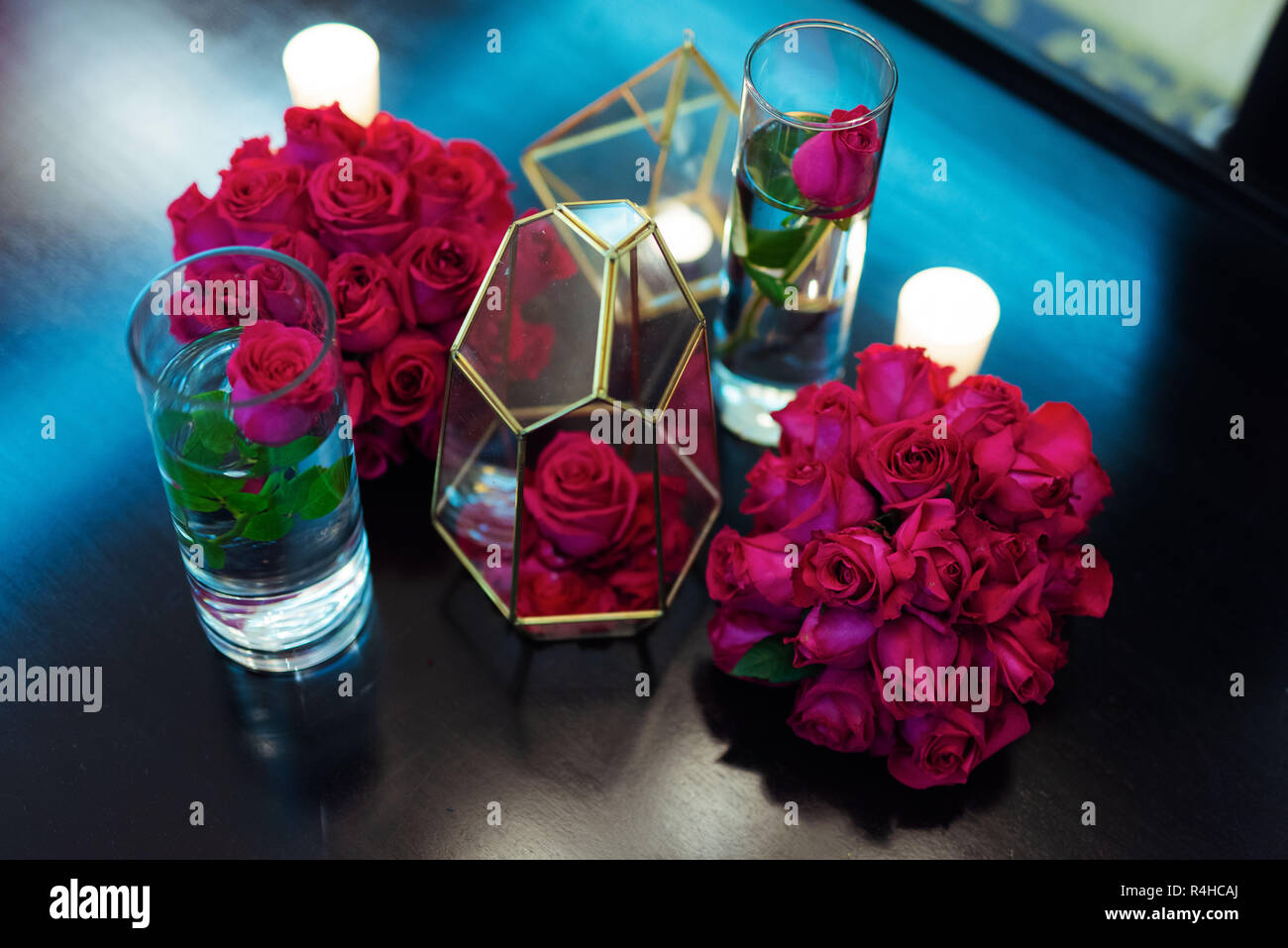 Rose rosse poste in bicchieri di vetro per la decorazione di interni Foto Stock