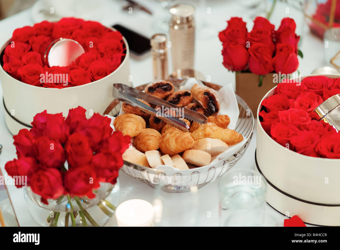 Sera tavolo da tè impostazione con rose rosse & close up di pasta di pane cotto al forno Foto Stock