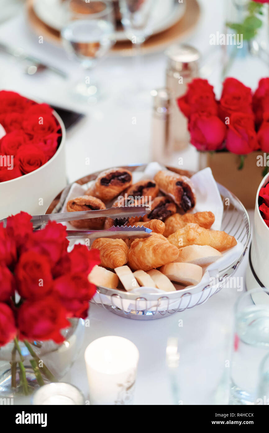 Sera tavolo da tè impostazione con rose rosse & close up di pasta di pane cotto al forno Foto Stock