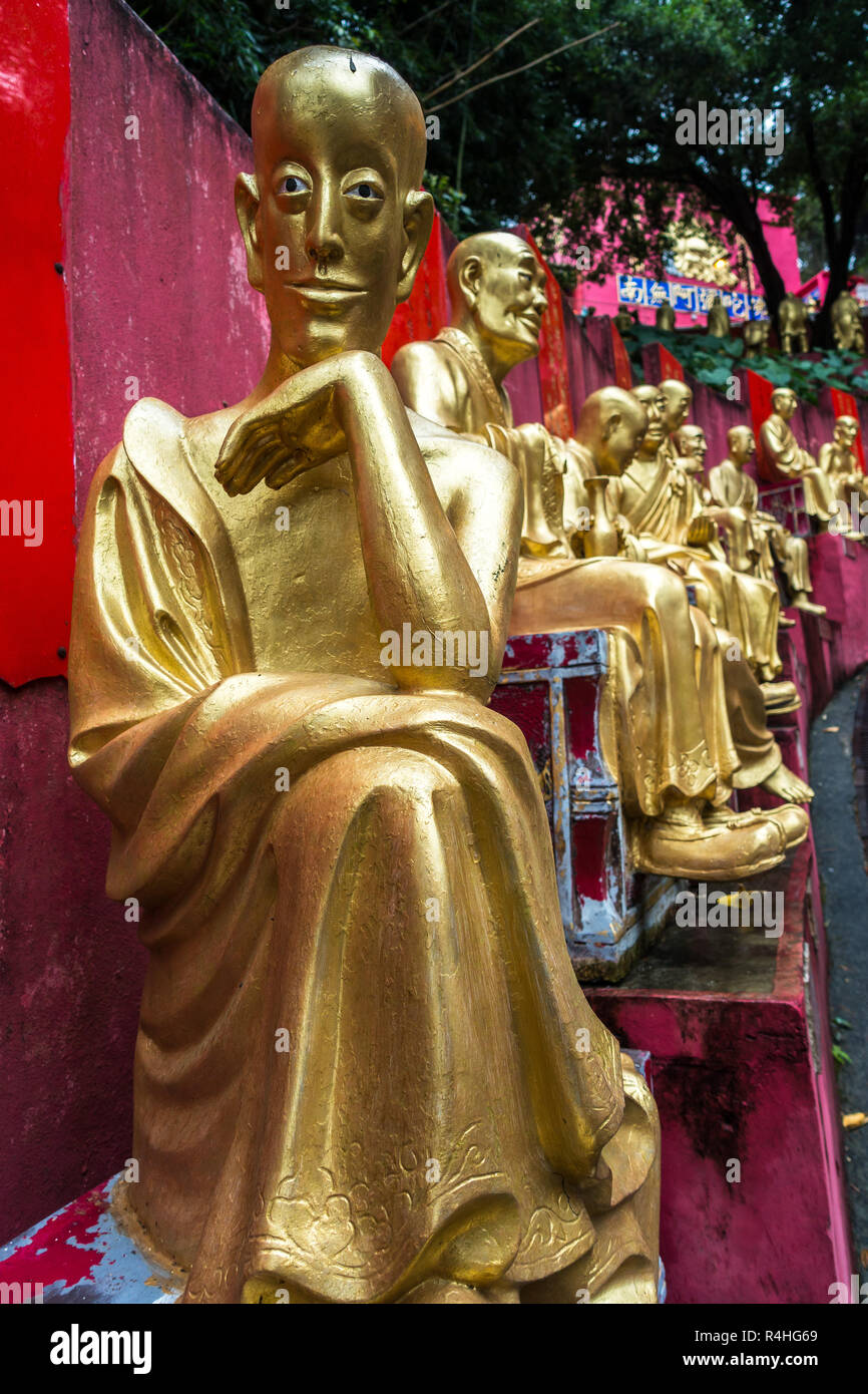 Uno dei Golden Statue di Buddha di rivestimento del percorso verso il Monastero dei Diecimila Buddha (l'uomo grasso TSZ), Hong Kong, Sha Tin, Nuovi Territori Foto Stock