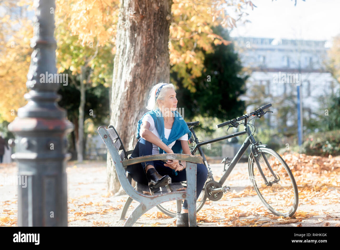 Donna seduta su una panchina nel parco, Germania Foto Stock