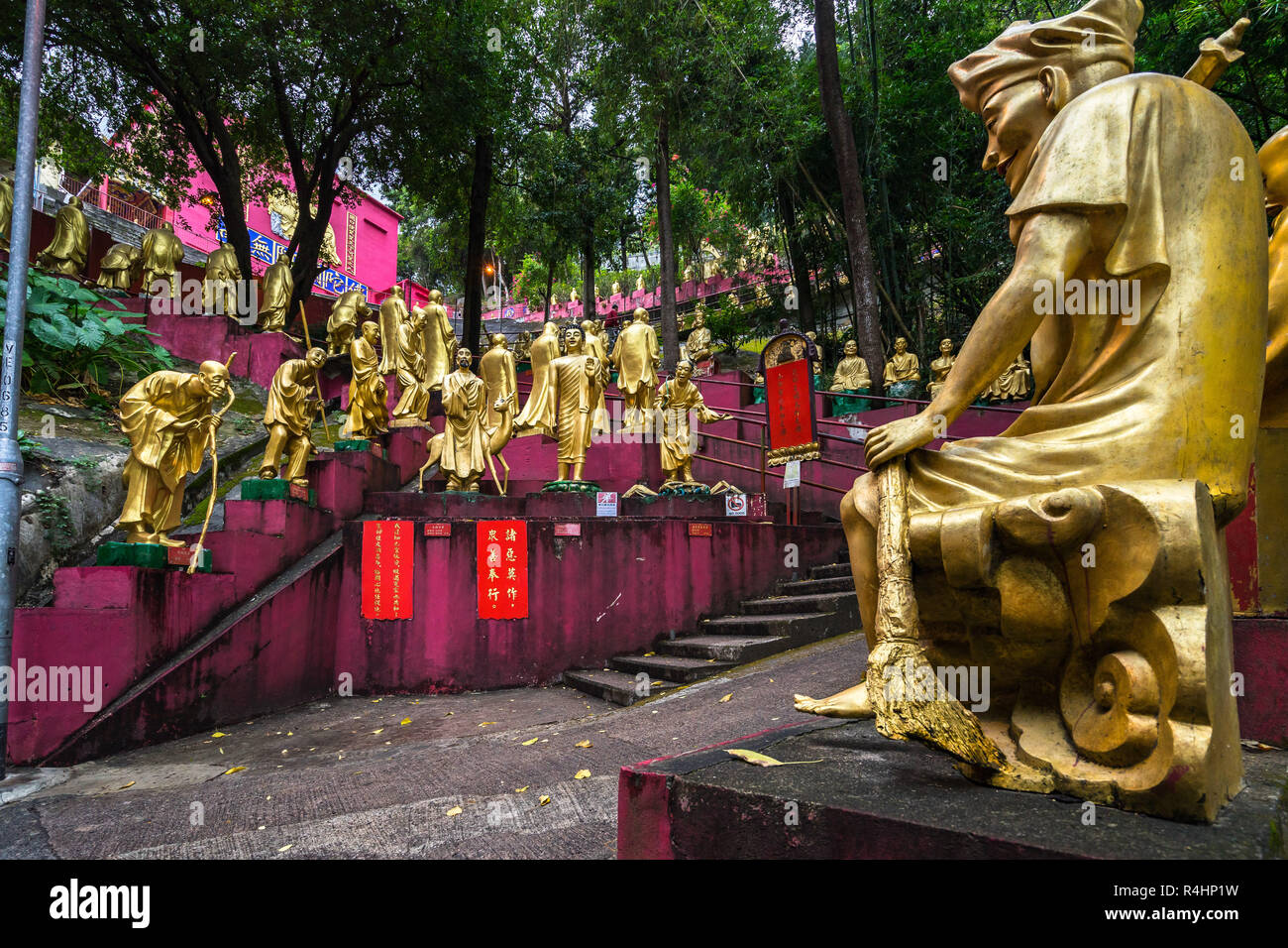 Lifesize statue di Buddha, ciascuno con diverse pose, lungo il sentiero verso il Monastero dei Diecimila Buddha (l'uomo grasso TSZ), Hong Kong, Sha Tin, nuovo Foto Stock