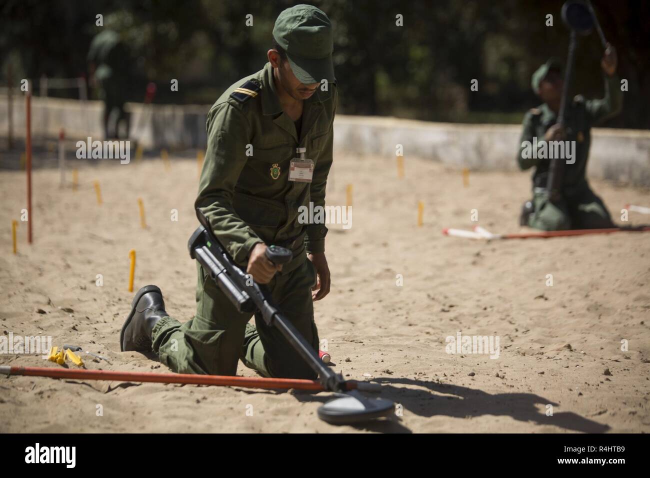 Un membro della Royal marocchino Forze Armate usa un rivelatore di metalli per spazzare per rischi di esplosione durante la miniera umanitario livello d'azione due di formazione a unire de secours et Sauvetage's Base, Kenitra, Marocco, Sett. 25, 2018. HMA livello due è il secondo livello in HMA scambio in cui i partner stranieri si riuniscono per il treno a fianco di U.S Marines e soldati al fine di imparare a mitigare i rischi di esplosione. Questa è la prima volta che la HMA livello due è stata condotta sul continente africano. Foto Stock