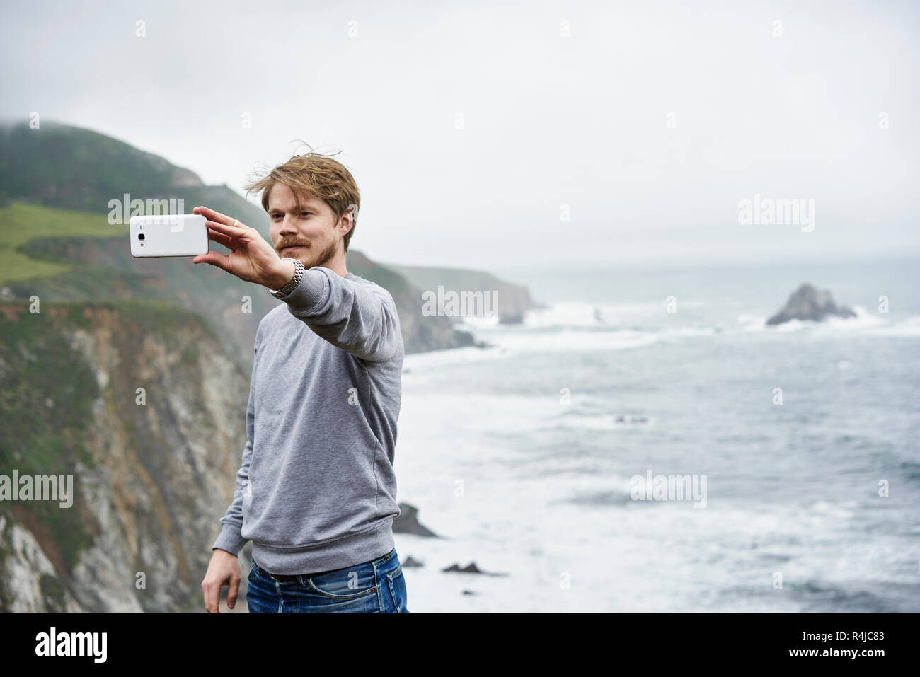 L'uomo prendendo selfie a Big Sur in California, Stati Uniti d'America Foto Stock