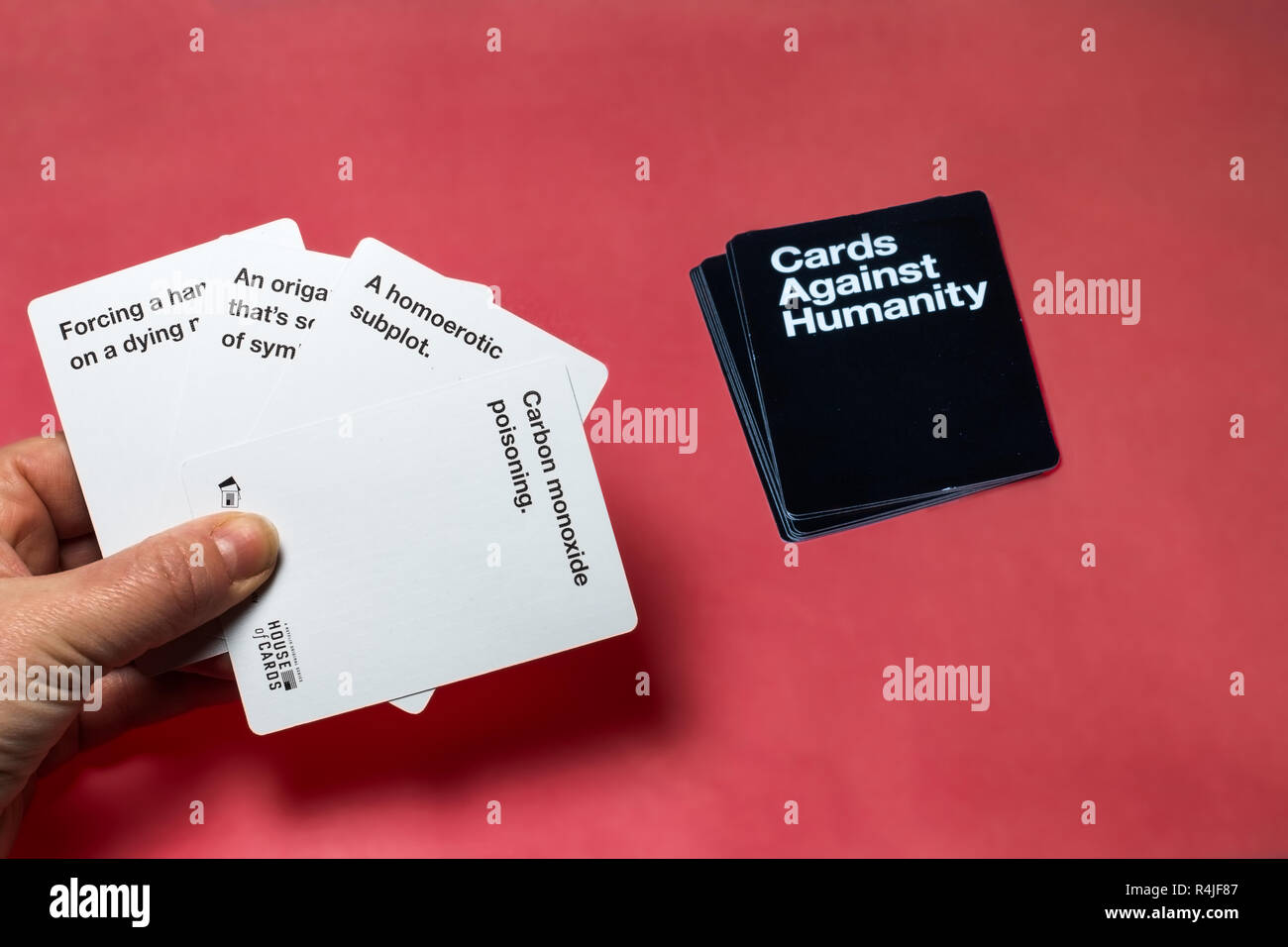 Mano che tiene un set di carte di carte contro l umanità carte gioco per  adulti Foto stock - Alamy