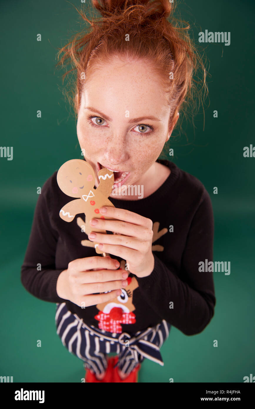 Giovane donna mangiare gingerbread man Foto Stock