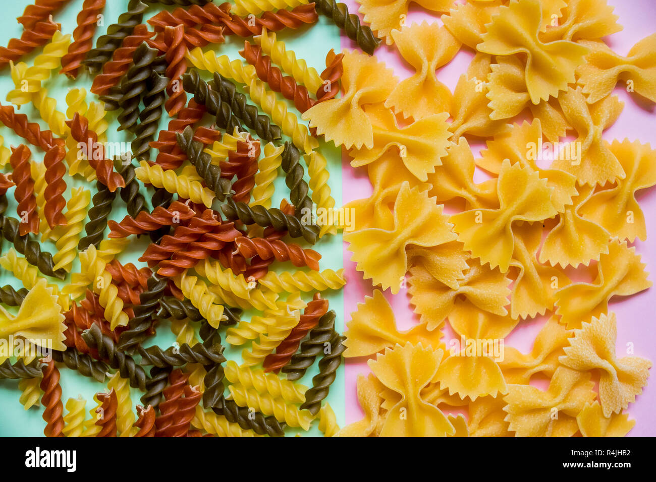 Delizioso Cibo Italiano sfondo.Materie di pasta a forma di papillon e penne pasta di pomodoro crudo, spinaci e pasta di grano. Colorata,tema alimentare Foto Stock