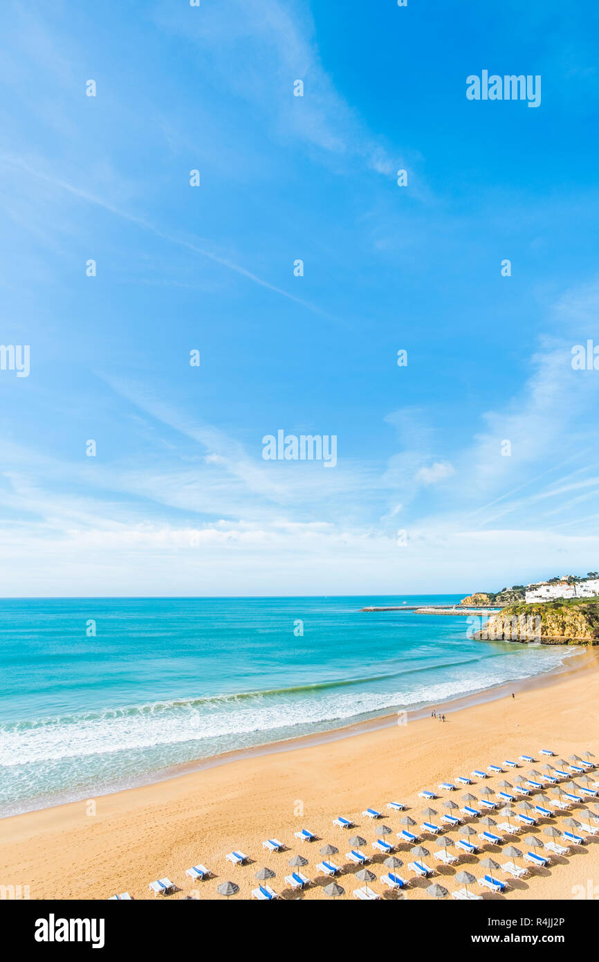 Sdraie e ombrelloni a praia de tonel appena prima della stagione di vacanze Foto Stock