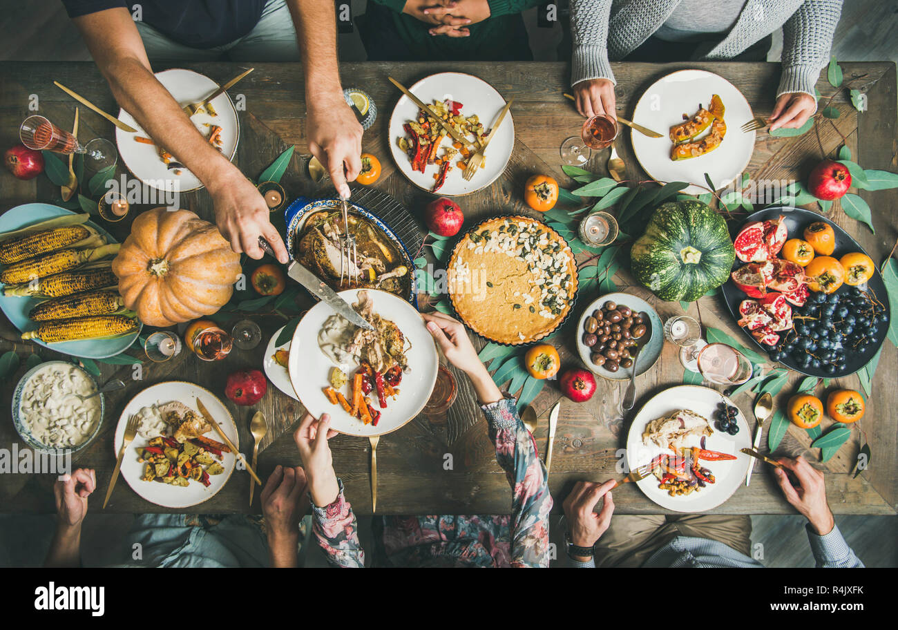 Tradizionale Festa del Ringraziamento feste. Piatto di laici amici o famiglia di mangiare stuzzichini vari e la Turchia alla festa di Natale tabella, vista dall'alto Foto Stock