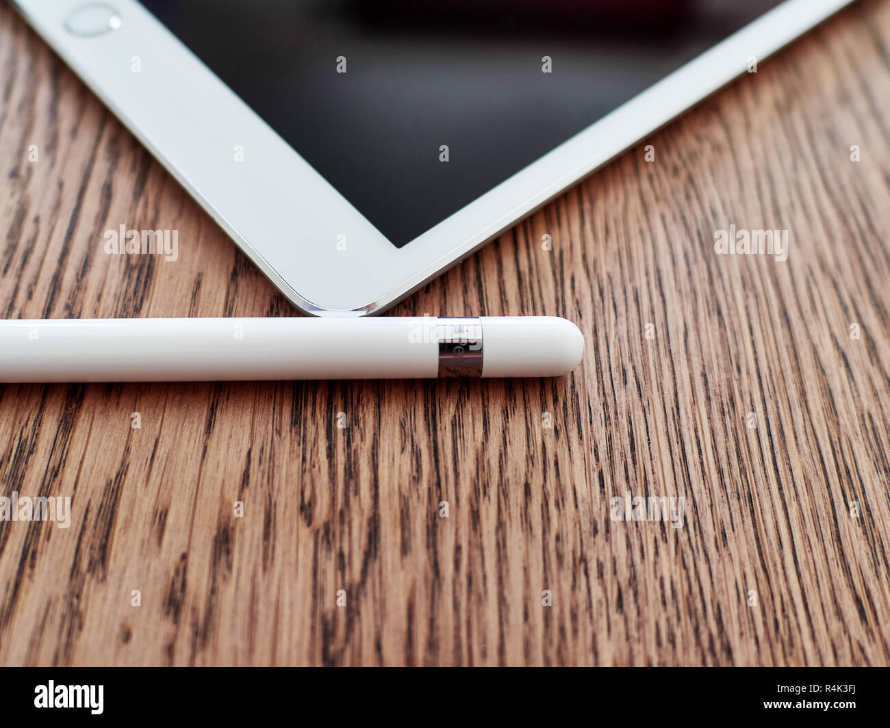 Matita di Apple e il suo cappuccio su un iPad di colore bianco su una superficie in legno Foto Stock