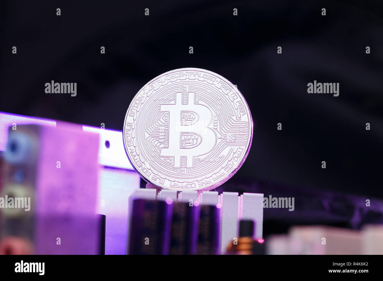Foto di crypto moneta, bitcoin e processore su sfondo rosa Foto Stock