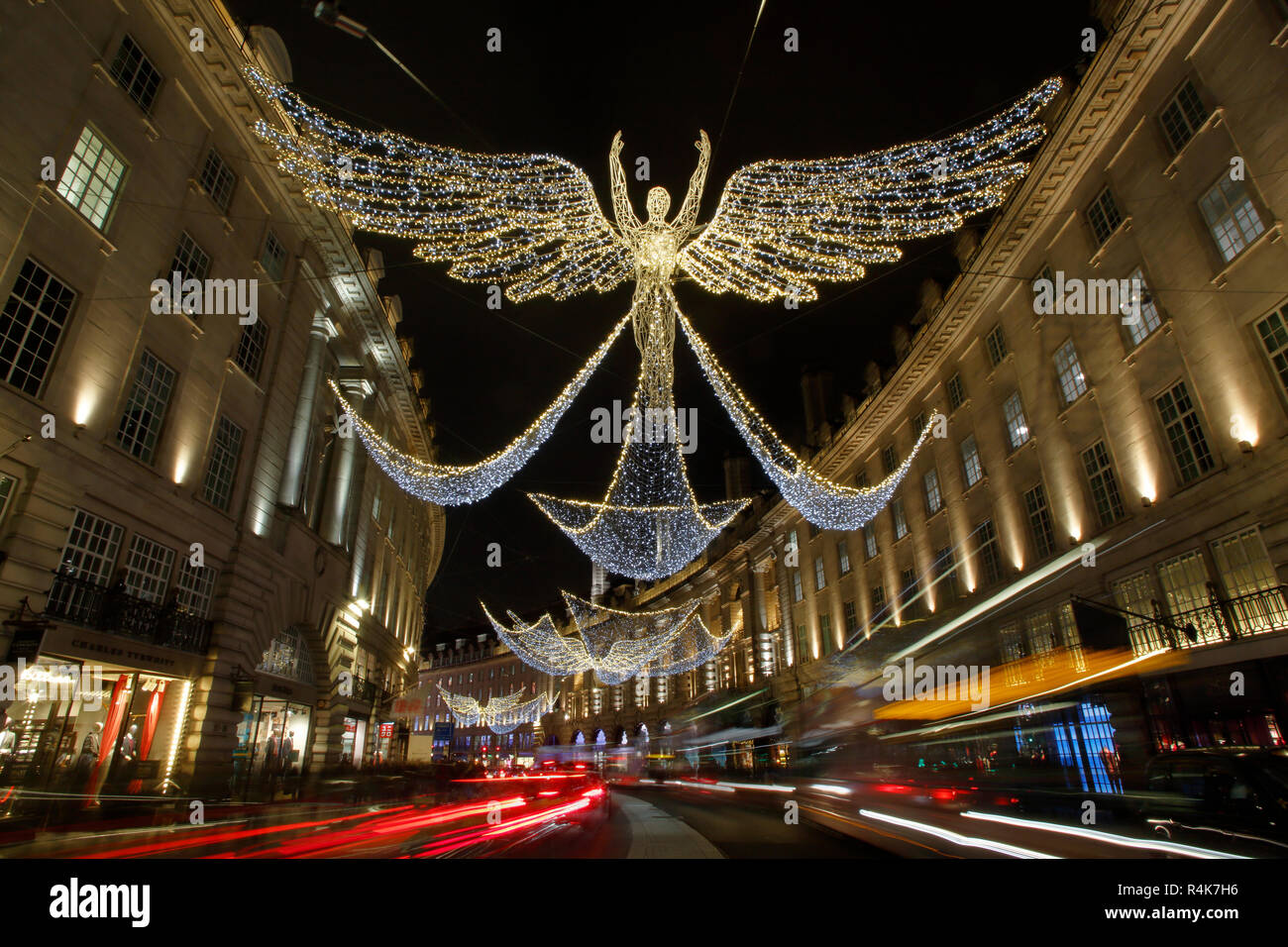 Regent Street le luci di Natale e sentieri di luce dal traffico in movimento, una lunga esposizione con sfocato gente occupata Foto Stock