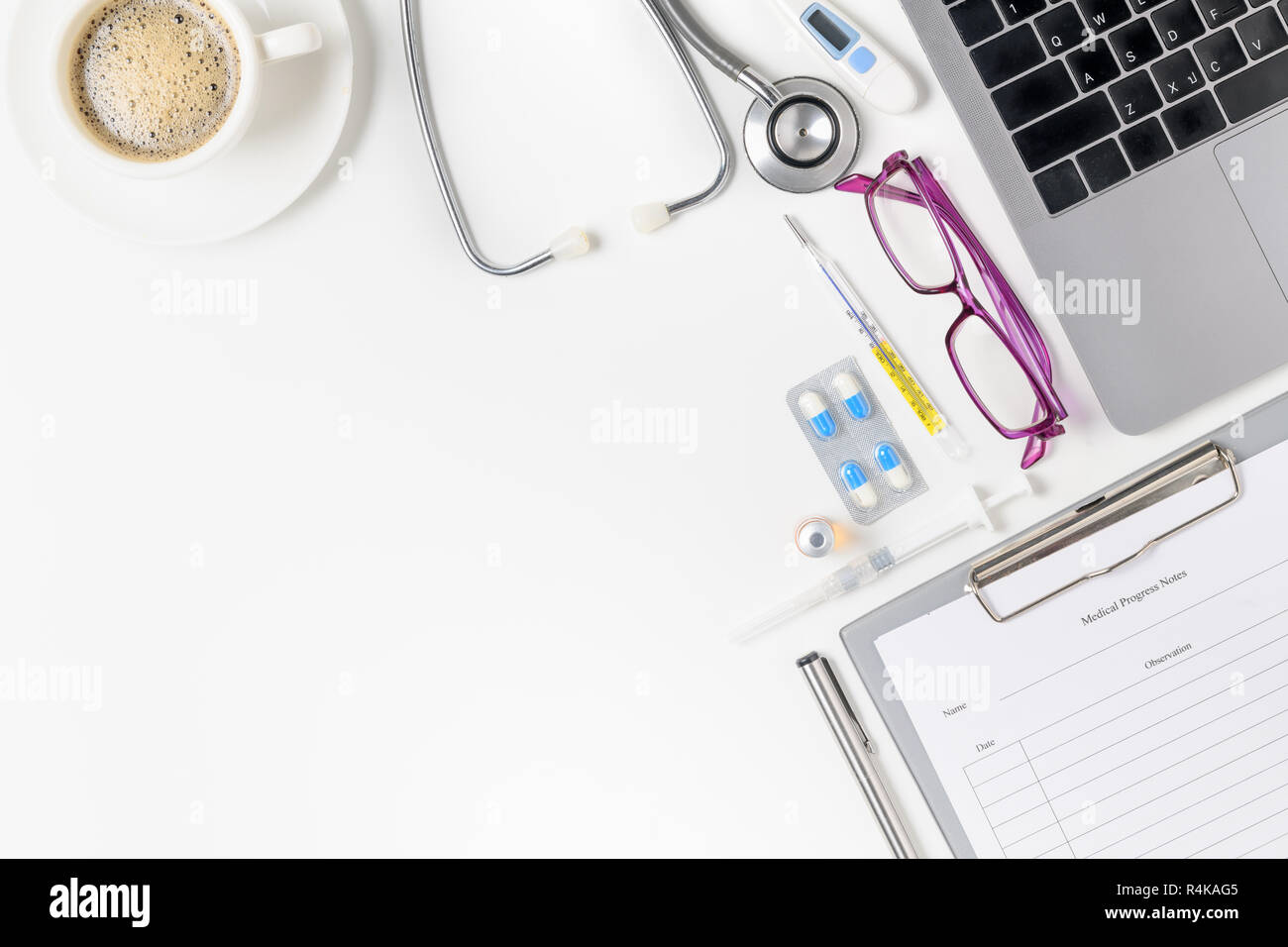 Vista superiore del medico scrivania con uno stetoscopio, caffè e laptop. Vista da sopra con copia spazio, laici piana. Foto Stock