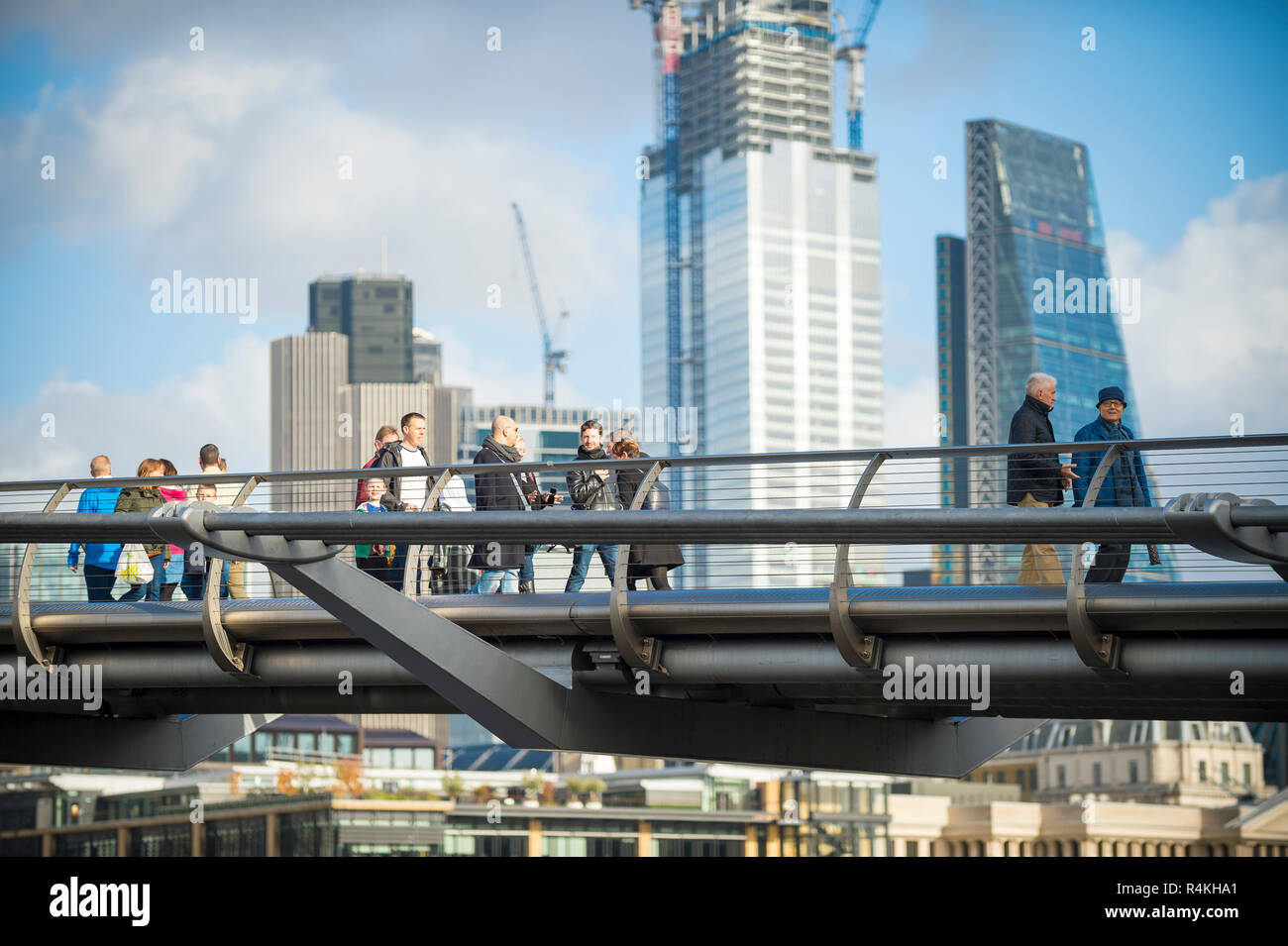 Londra - 10 novembre 2018: pedoni attraversano il Millennium Bridge di fronte alcuni dei 13 previsti grattacieli in costruzione nella città. Foto Stock
