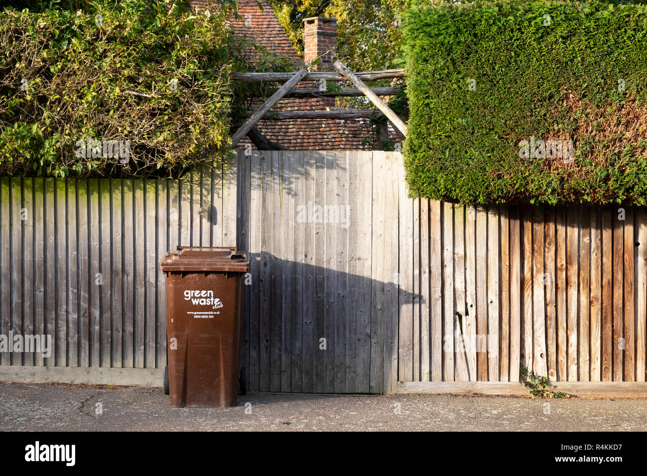 Il verde del riciclo dei rifiuti bin al di fuori di una casa Foto Stock