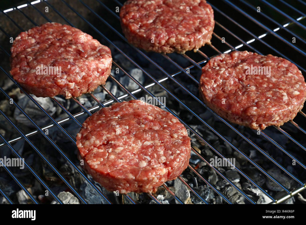 Close up materie carni bovine o le carni di maiale barbecue hamburger per hamburger cotta alla brace sulla griglia per il barbecue, ad alto angolo di visione Foto Stock