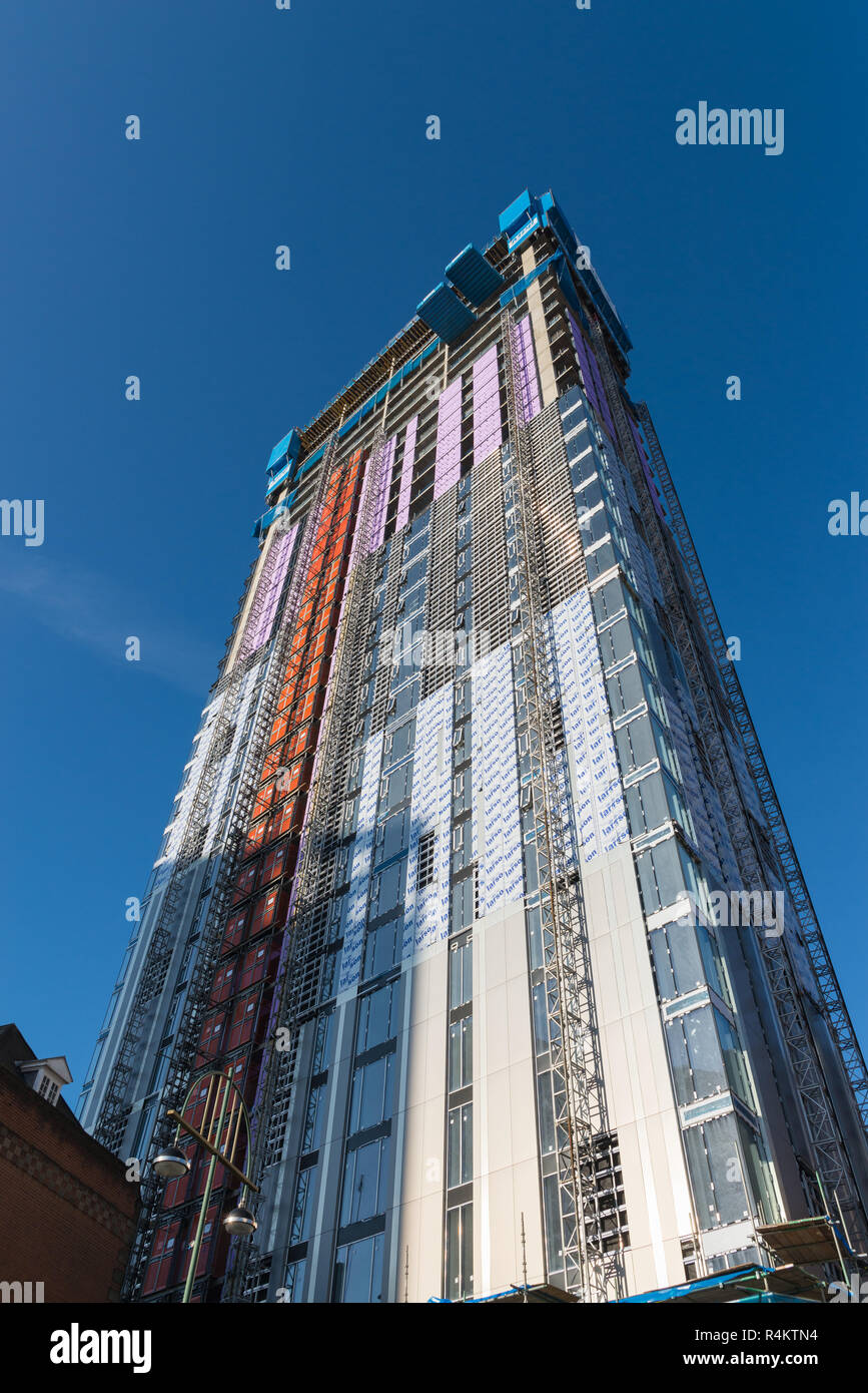 Costruzione di edificio alto mostrante la struttura e di isolamento e rivestimento essendo montato Foto Stock