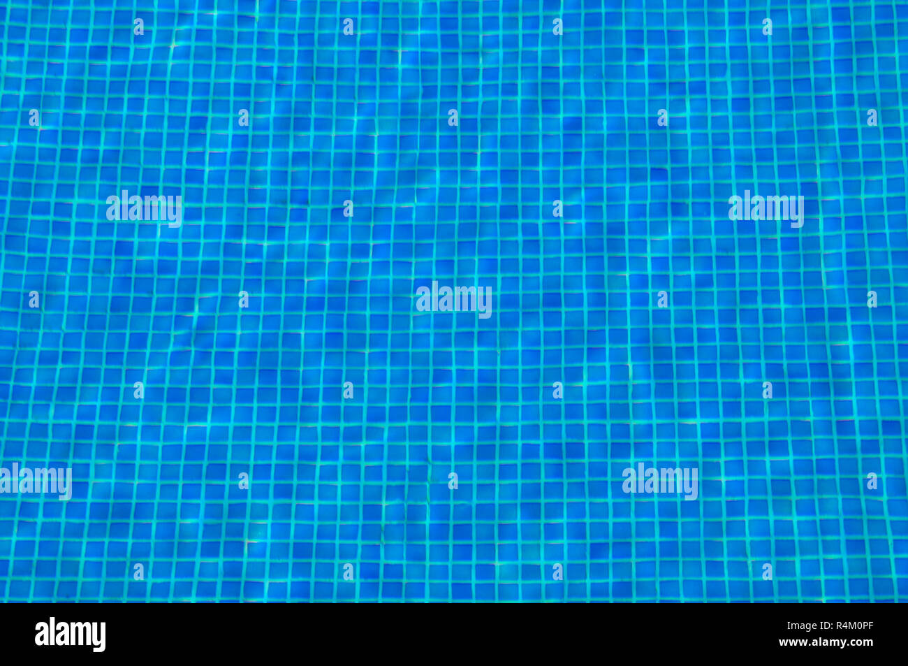 Dettaglio del mosaico di piastrelle del pavimento in una piscina visto attraverso acque torbide. Foto Stock
