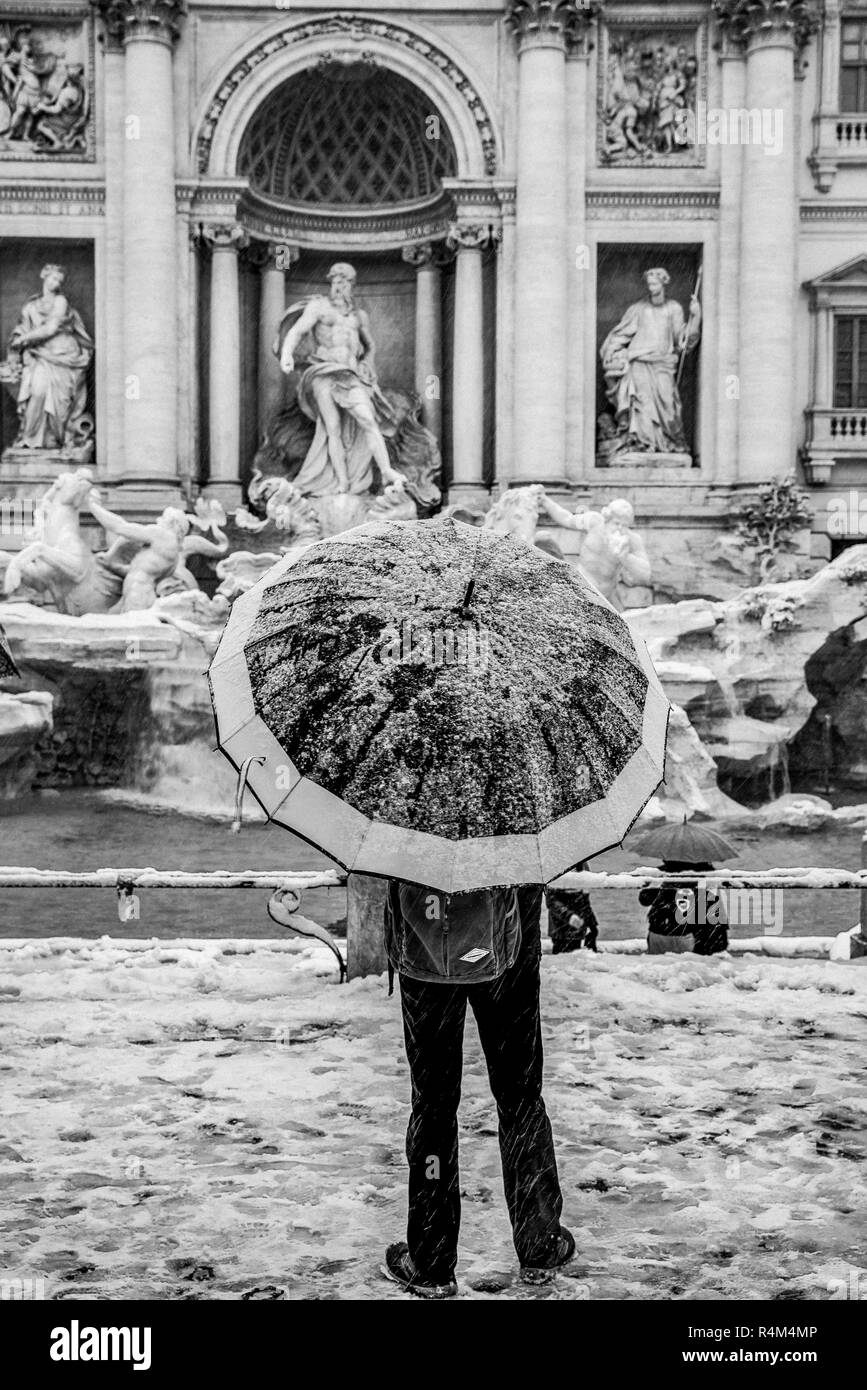 Italia Lazio Roma Fontana di Trevi con neve e uomo con umbela Foto Stock
