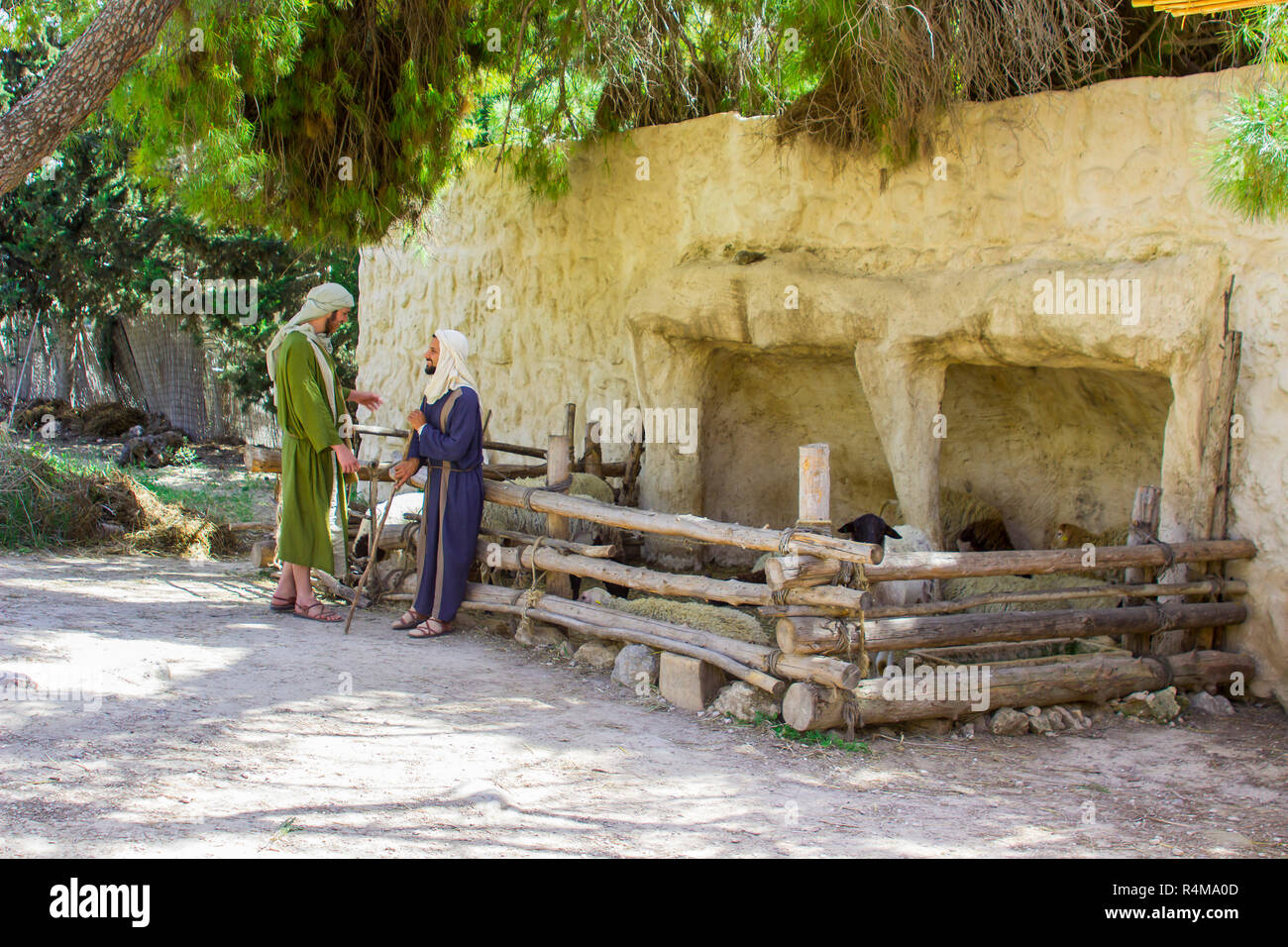 Giovani uomini in abito di periodo al recinto delle pecore nel 1 ° secolo Nazareth Village Museum in Israele. Questa esperienza di un villaggio è progettato per dare il vistor un Foto Stock