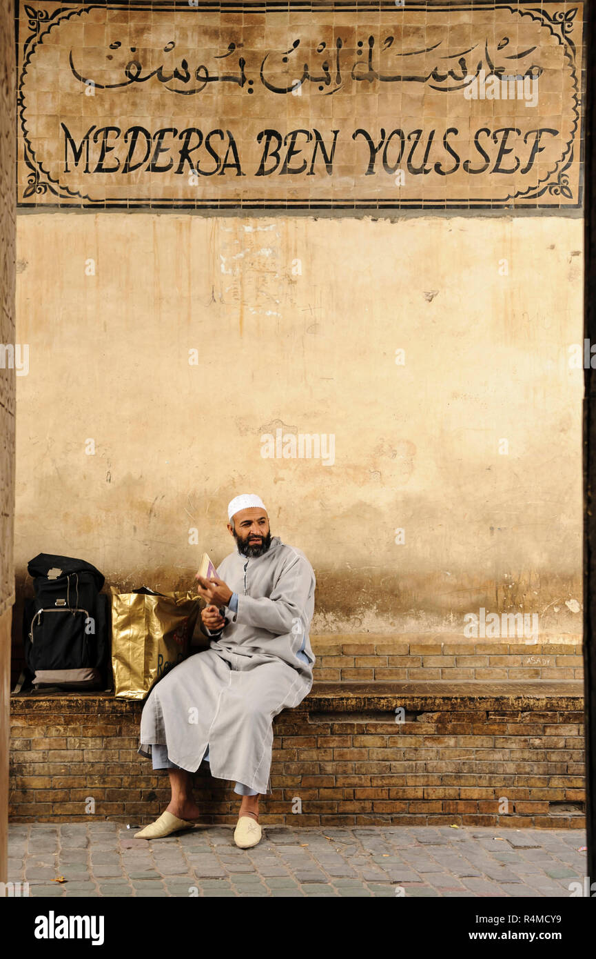18-04-11. Marrakech, Marocco. Marrakech, Marocco. Una guida turistica attende fuori del Ben Youssef Madrasa era un collegio islamico di Marrakech, Marocco Foto Stock