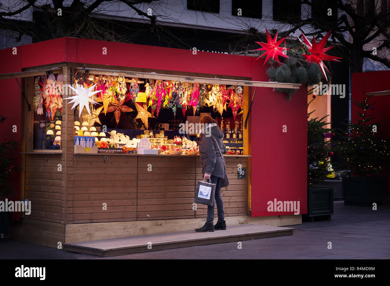 Lubecca, Germania - 26 novembre 2018: la donna è in piedi di fronte a uno stand di vendita presso il mercato di natale di acquistare regali o decorazione di illuminazione Foto Stock