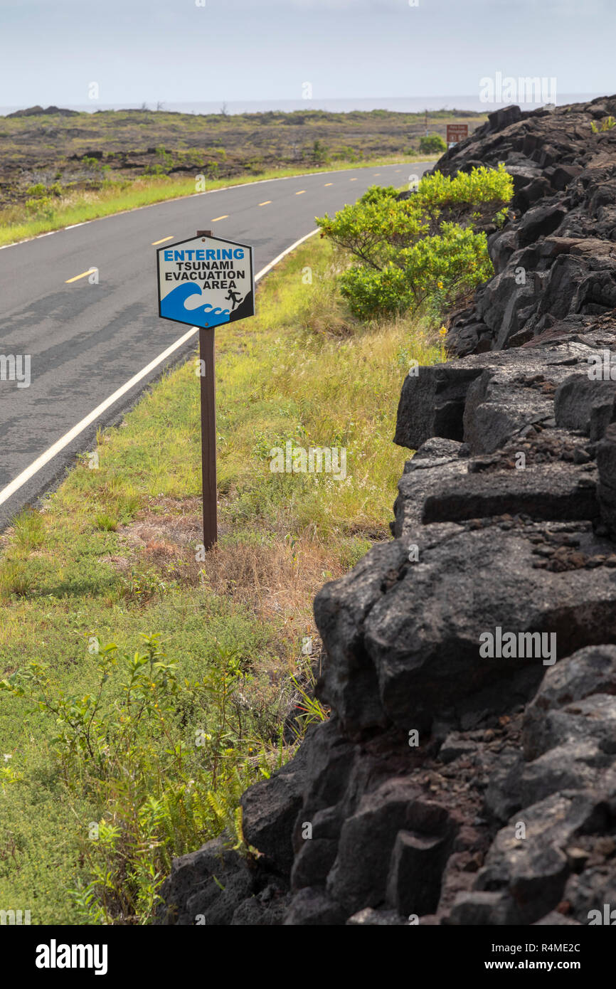 Parco Nazionale dei Vulcani delle Hawaii, Hawaii - un segno lungo la catena di crateri Road vicino all'Oceano Pacifico designa un tsunami zona di evacuazione. Foto Stock