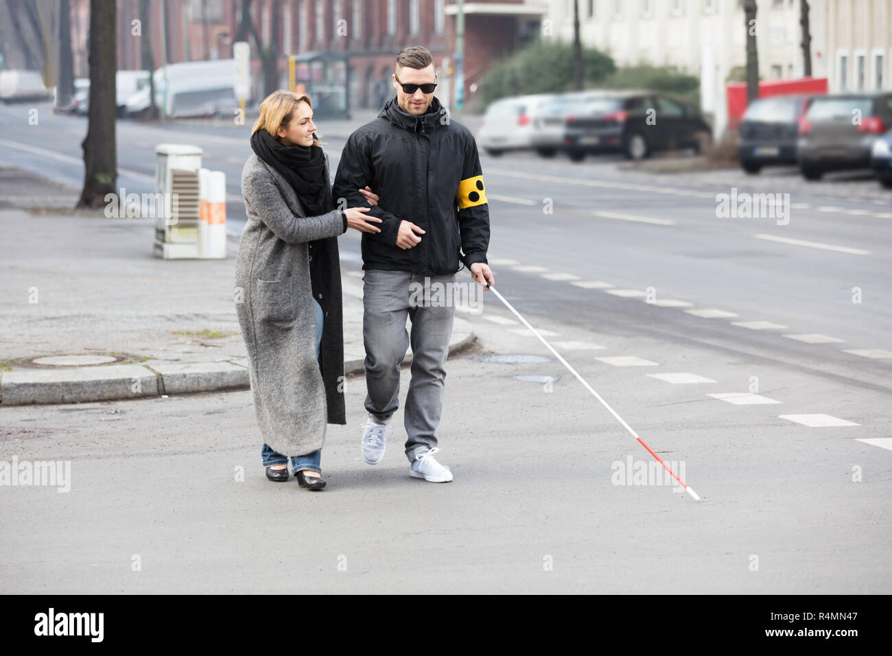 La donna che assiste cieco su strada Foto Stock