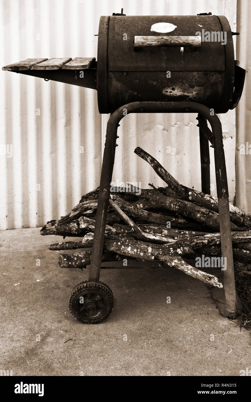Vecchio, logoro grill con registri secchi impilati sul ripiano inferiore. Foto Stock