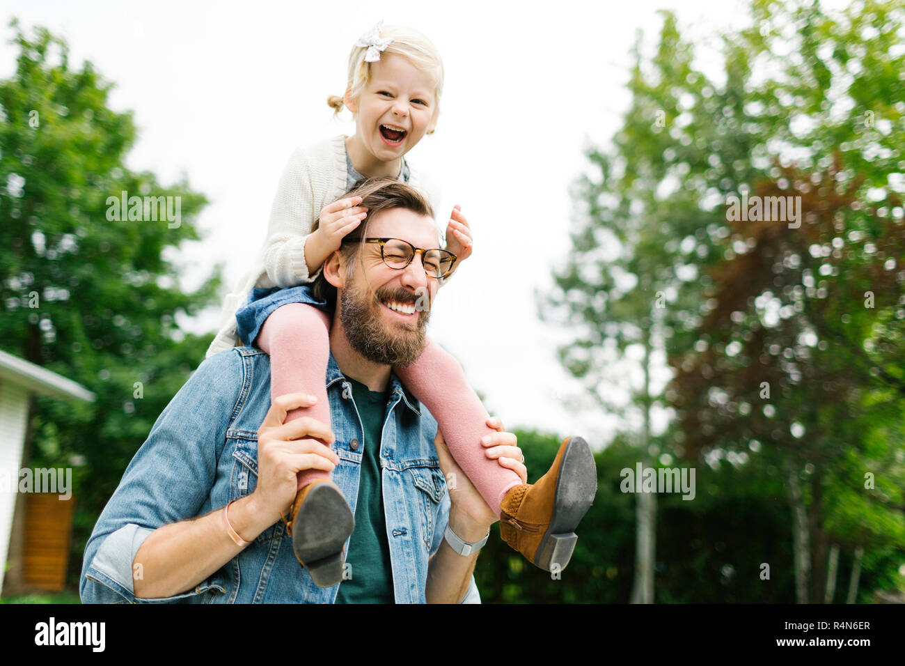 Padre dando figlia piggyback ride Foto Stock
