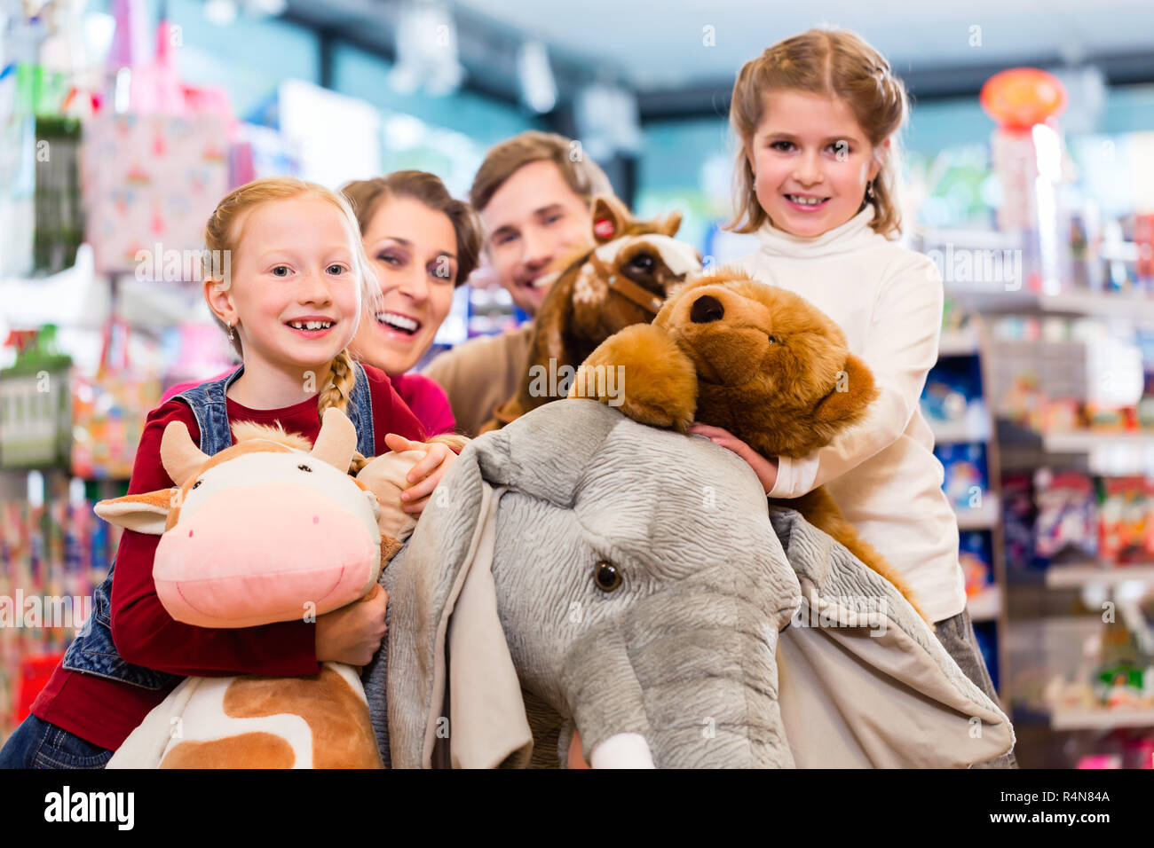 Famiglia con ripieni elefante in negozio di giocattoli a giocare Foto Stock