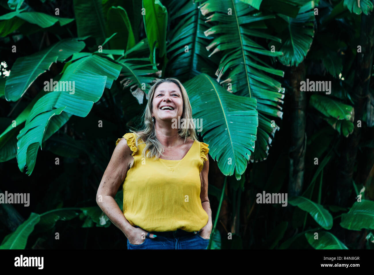 Donna sorridente da foglie di palma Foto Stock