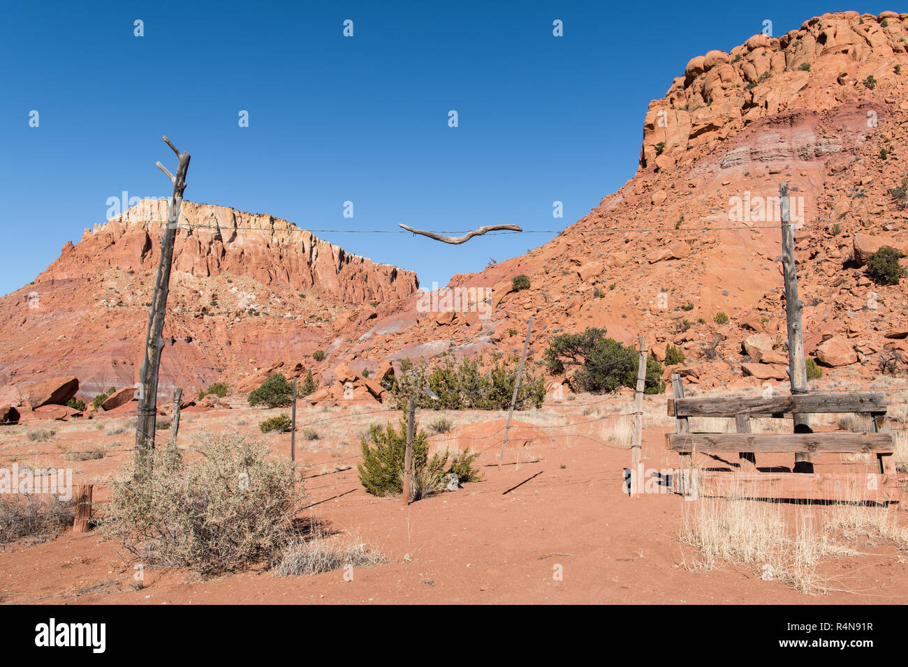Cancello rustico in un ranch portando ad un paesaggio di coloratissimi red rock mesas vicino Abiquiu, Nuovo Messico del sud-ovest americano Foto Stock