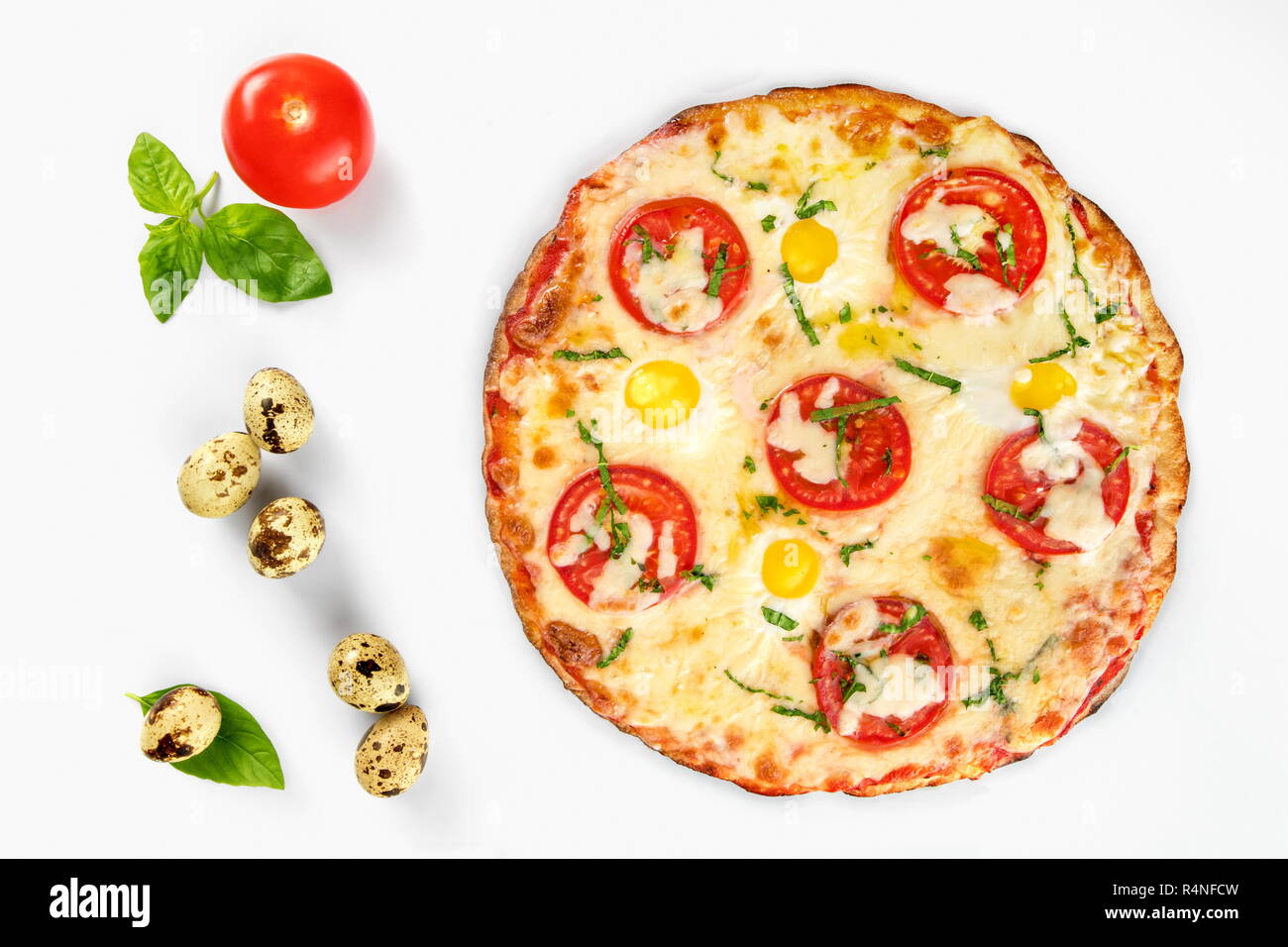Pizza caprese vista superiore con uova di quaglia con pomodoro e basilico accanto, su sfondo bianco Foto Stock