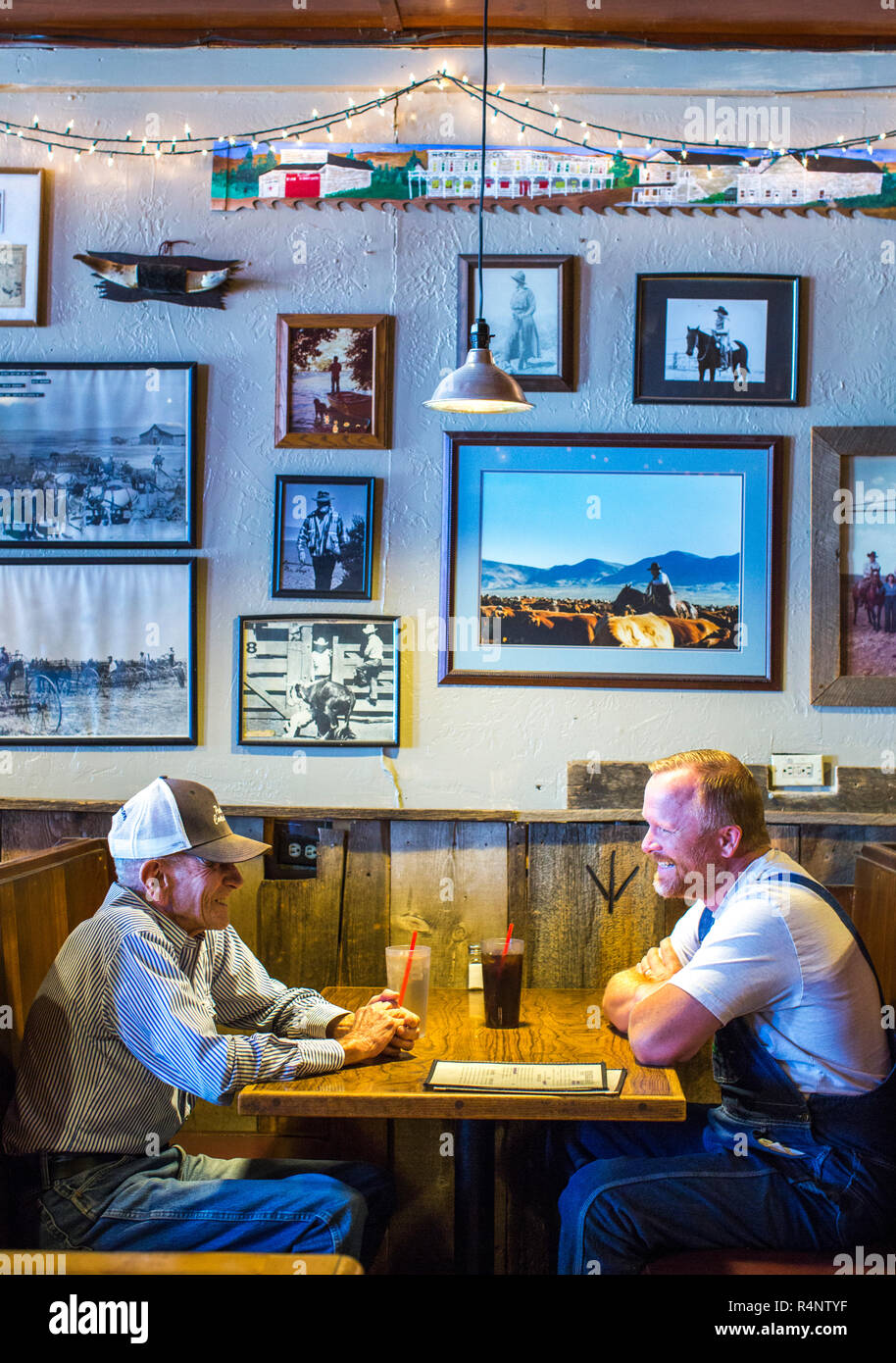 Vista laterale di due uomini maturi seduto al tavolo nel ristorante, Paisley, Oregon, Stati Uniti d'America Foto Stock