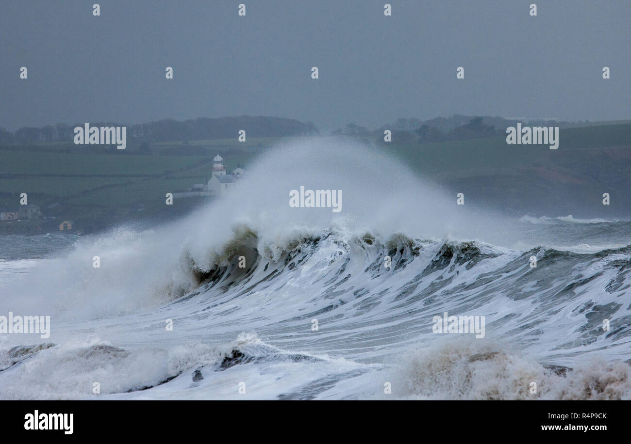 Myrtleville, Cork, Irlanda. 28 Novembre,2018. Roches Point lighthouse in background come grandi onde infrangersi sulla riva durante la tempesta Diana a Myrtleville, Co. Cork, Irlanda. Credito: David Creedon/Alamy Live News Foto Stock