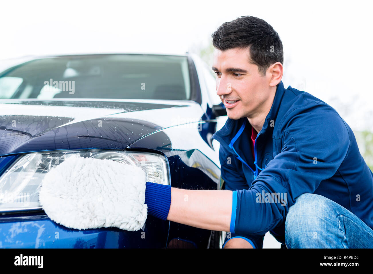 Duro lavoro l'uomo la lucidatura auto con bianco guanto in microfibra Foto  stock - Alamy