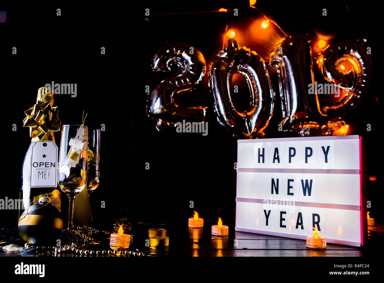 Il veglione di Capodanno celebrazione foto concettuale, con decorazione di Natale in tono dorato, una bottiglia di champagne e un lightbox con i saluti del testo e in th Foto Stock