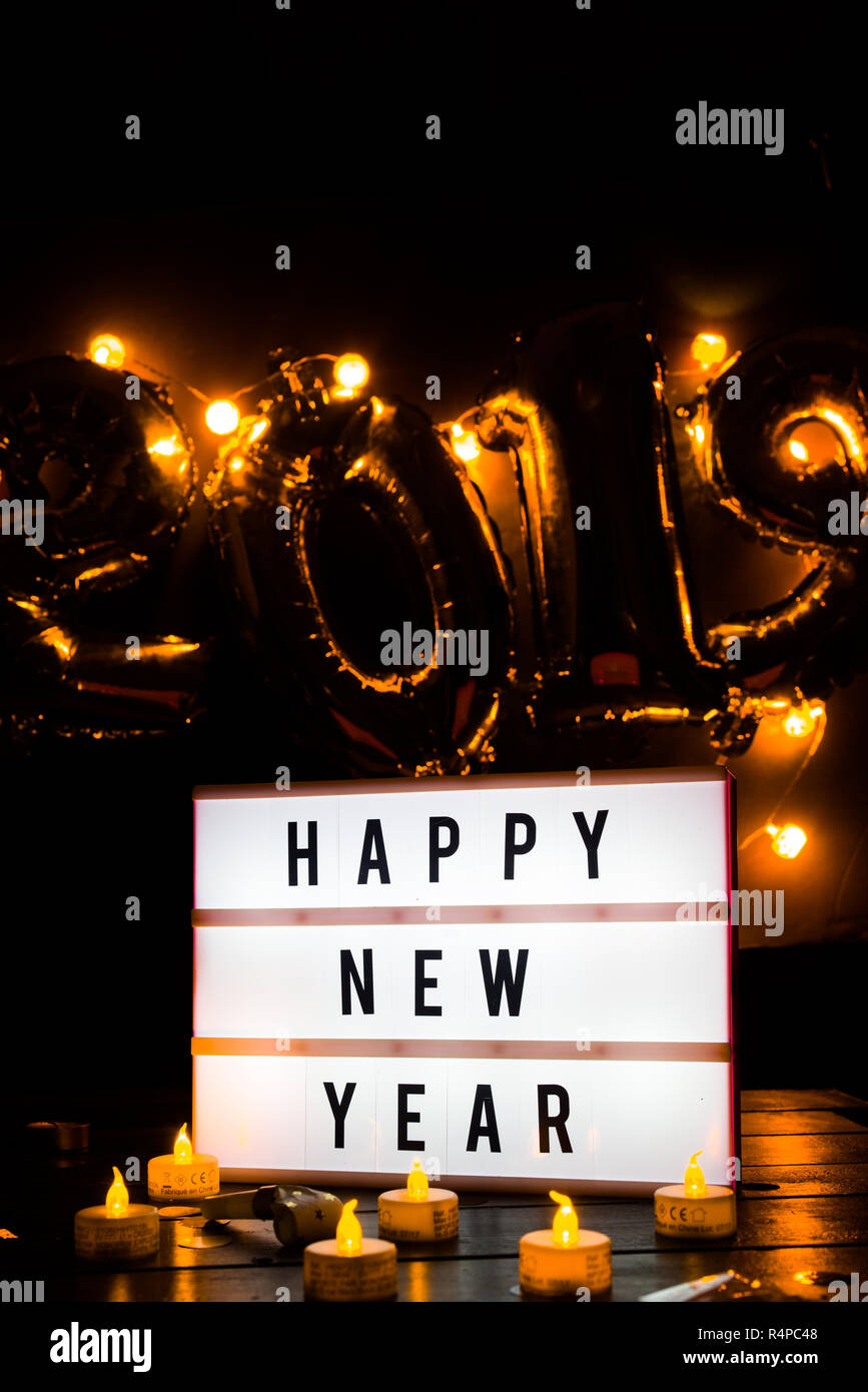 Il veglione di Capodanno celebrazione foto concettuale, con decorazione di Natale in tono dorato, una bottiglia di champagne e un lightbox con i saluti del testo e in th Foto Stock