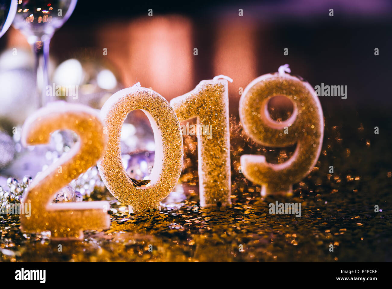 Il veglione di Capodanno celebrazione sfondo con coppia di flauto,candele formando il numero 2019, glitter e sfondo sfocato, con albero di natale luce f Foto Stock