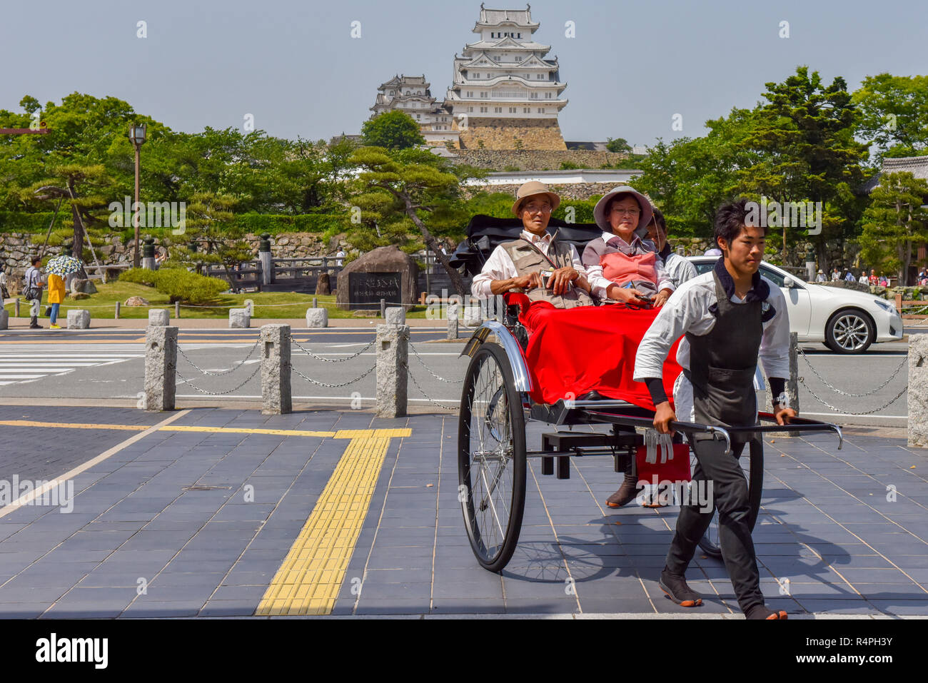 I turisti su un Tuk Tuk accanto al castello di Himeji Giappone Foto Stock