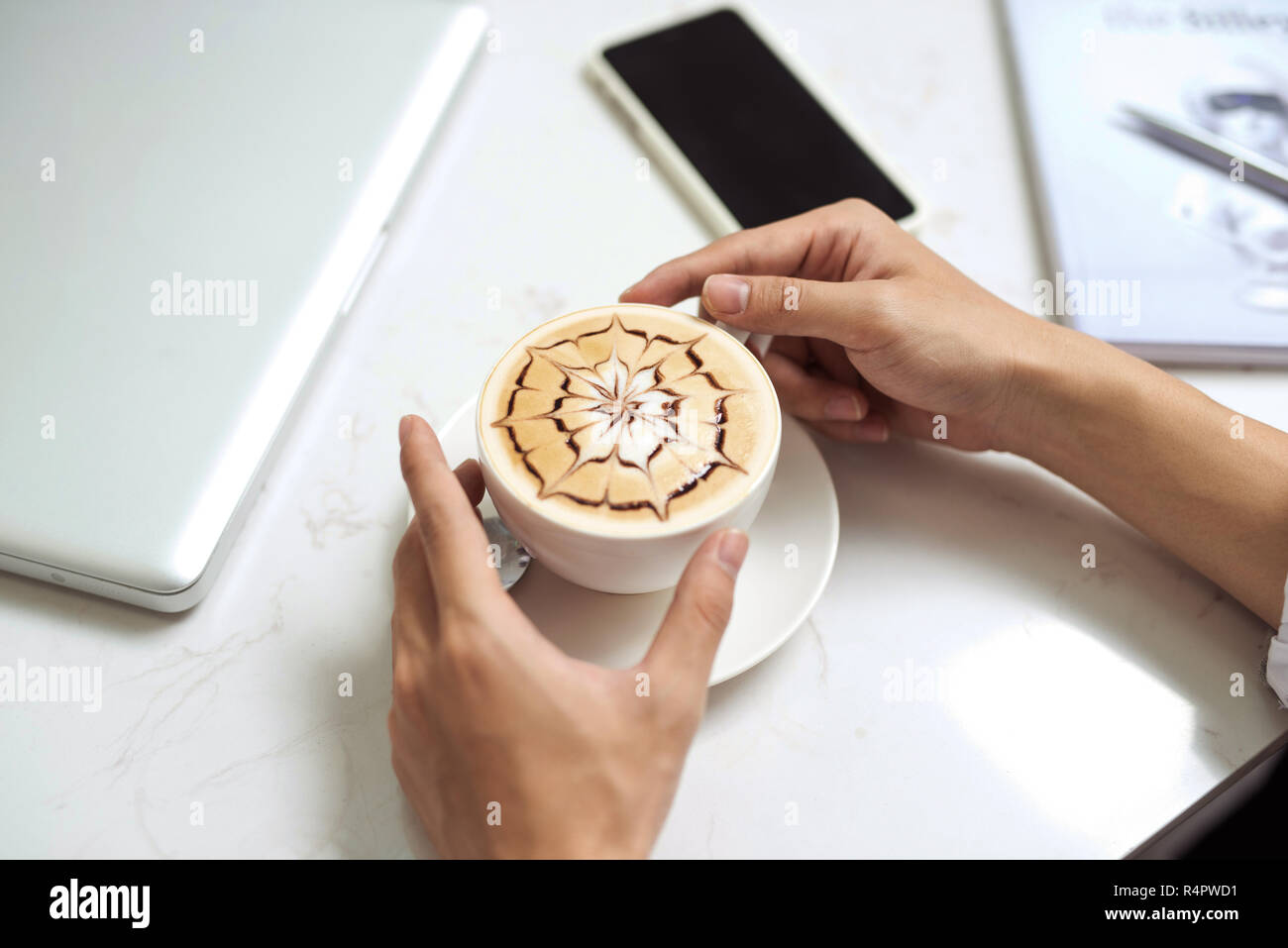 Imprenditore asiatico tramite telefono cellulare durante la pausa caffè sul tavolo in coffee shop Foto Stock